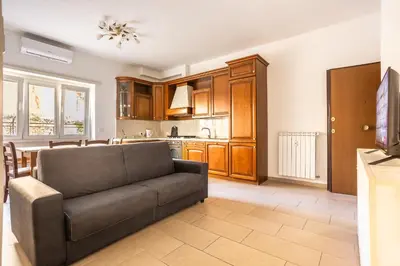 a living room with a couch and a kitchen at Portside Aparthotel in Rome