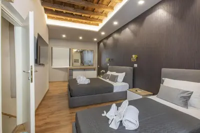 a hotel room with two beds and a tv at Sweet House Campo de’ Fiori in Rome