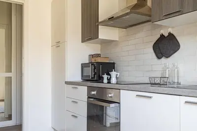 a kitchen with white cabinets and a microwave at [Flaminio * * * * *] - Loft con Giardino in Rome