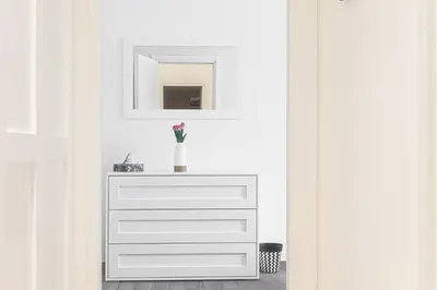 a white dresser with a mirror and a vase on it at [Flaminio * * * * *] - Loft con Giardino in Rome