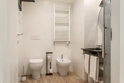 a white bathroom with a toilet and a sink at [Flaminio * * * * *] - Loft con Giardino in Rome