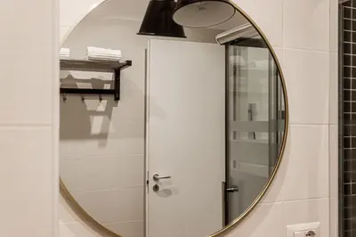 a bathroom with a round mirror and a shower at [Flaminio * * * * *] - Loft con Giardino in Rome