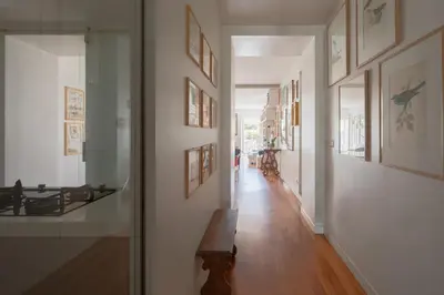 a hallway with a bench and paintings on the walls at Cesarina Home in Rome