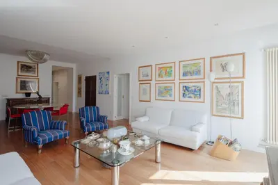 a living room with a white couch and blue chairs at Cesarina Home in Rome