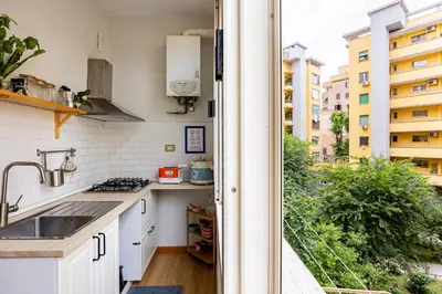 a kitchen with white cabinets and a view of a building at Donna Olimpia tra Gianicolo e Trastevere in Rome