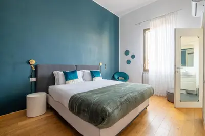 a bedroom with a large bed with blue walls at Elegant Apt with Two Bedrooms in Rome