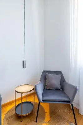 a blue chair and a table in a room at Elegant Apt with Two Bedrooms in Rome