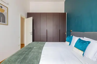 a bedroom with a large white bed with blue pillows at Elegant Apt with Two Bedrooms in Rome