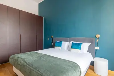 a bedroom with a large bed with a blue wall at Elegant Apt with Two Bedrooms in Rome