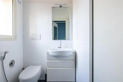 a white bathroom with a sink and a mirror at Elegant Apt with Two Bedrooms in Rome