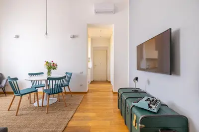 a living room with a table and chairs and a flat screen tv at Elegant Apt with Two Bedrooms in Rome