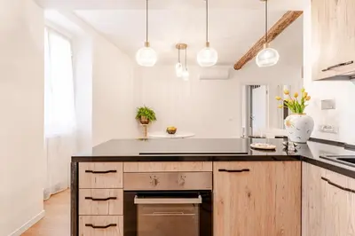 a kitchen with a black counter top and wooden cabinets at In the shadow of the Colosseum in Rome