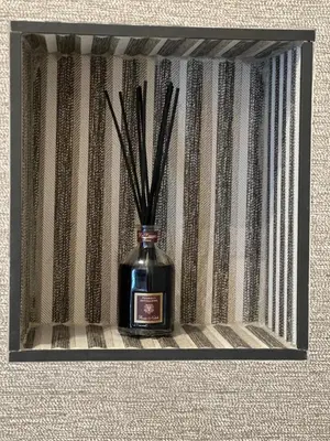 a bottle with sticks in it sitting on a shelf at In the shadow of the Colosseum in Rome