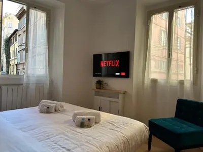 a bedroom with a bed and a tv on the wall at In the shadow of the Colosseum in Rome