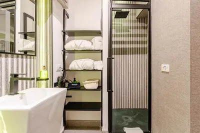 a bathroom with a sink and a shower with towels at In the shadow of the Colosseum in Rome