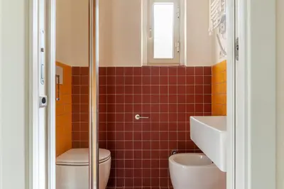 a bathroom with a toilet and a sink at GuestHost - Colosseo & San Clemente Apartment in Rome