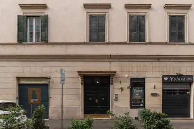 a building with black doors and windows on a street at GuestHost - Colosseo & San Clemente Apartment in Rome