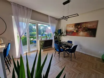 a living room with a table and chairs and a large window at Vacanze Romane Apartments - Vatican City in Rome