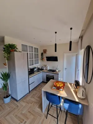 a kitchen with a table and two blue chairs at Vacanze Romane Apartments - Vatican City in Rome