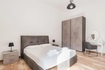 a bedroom with a large bed and a desk at WMR Apartment near Vatican in Rome