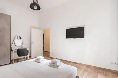 a white bedroom with a bed and a television at WMR Apartment near Vatican in Rome