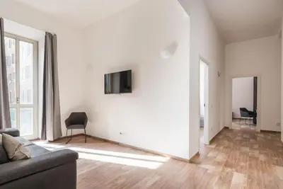 a living room with a couch and a television on a wall at WMR Apartment near Vatican in Rome