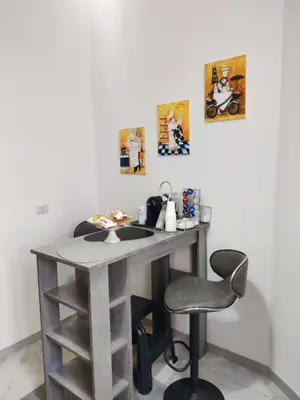 a desk in a room with a chair and paintings at Portami a Roma in Rome