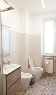 a white bathroom with a toilet and a sink at Portami a Roma in Rome
