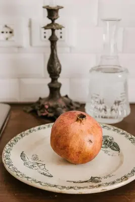 a pomegranate sitting on a plate on a table at Casa Riva 1920 in Rome