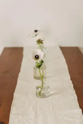 a table with three flowers in a glass vase at Casa Riva 1920 in Rome