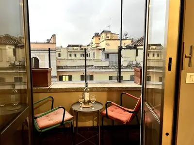 a balcony with a table and two chairs and a window at La Casa del giornalista - ItalyHolidayHouse in Rome