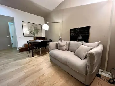 a living room with a white couch and a table at La Casa del giornalista - ItalyHolidayHouse in Rome