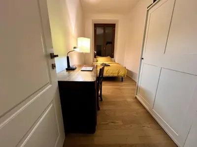 a room with a desk and a bed in a room at La Casa del giornalista - ItalyHolidayHouse in Rome