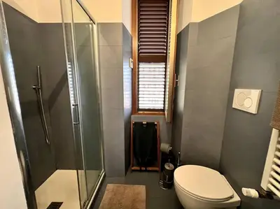a bathroom with a toilet and a glass shower at La Casa del giornalista - ItalyHolidayHouse in Rome