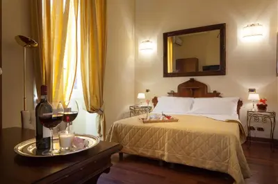 a bedroom with a bed with a mirror and glasses of wine at Vatican Domus in Rome