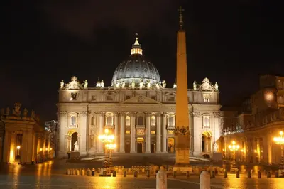 a large building with a tower in front of it at night at Vatican Domus in Rome