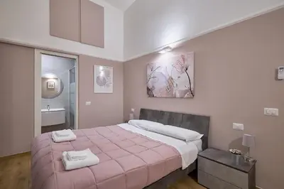 a bedroom with a large bed with a pink blanket at Casa Pallini Luxury Apartment in Rome