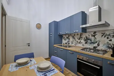 a kitchen with blue cabinets and a wooden table at Casa Pallini Luxury Apartment in Rome