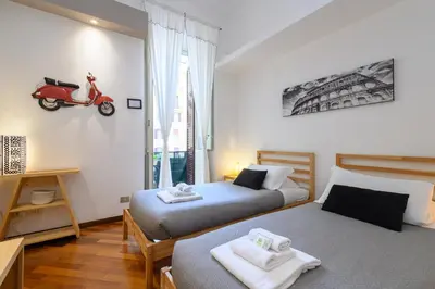 two beds in a room with a scooter on the wall at Suite Apartment Prati in Rome