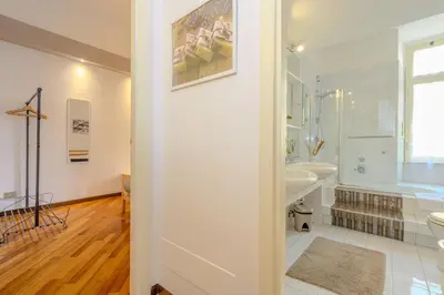 a white bathroom with a tub and a sink at Suite Apartment Prati in Rome