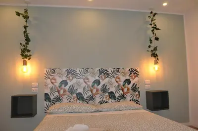 a bedroom with a bed with a floral headboard and speakers at corso francia suite in Rome