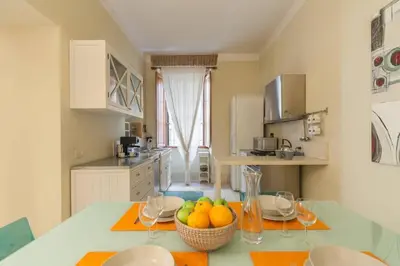 a kitchen with a table with a bowl of fruit on it at BORGO PIO - quite and spacious apt in Rome