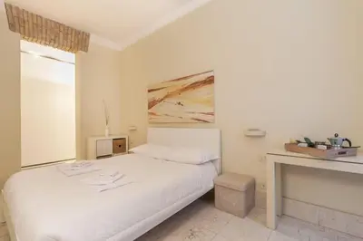 a white bedroom with a bed and a fireplace at BORGO PIO - quite and spacious apt in Rome