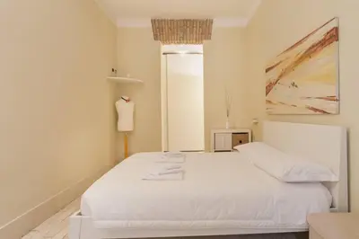 a bedroom with a white bed and a painting at BORGO PIO - quite and spacious apt in Rome