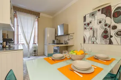 a kitchen with a table with plates and fruit on it at BORGO PIO - quite and spacious apt in Rome