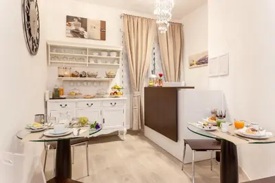 a kitchen with two tables and a refrigerator at Relais 155 Guest House in Rome