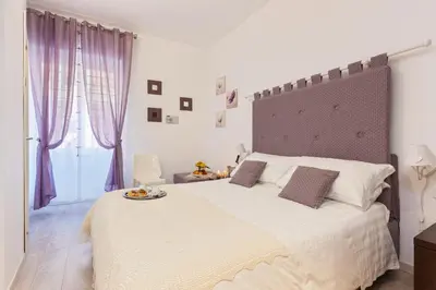 a white bed with a plate of food on it at Relais 155 Guest House in Rome