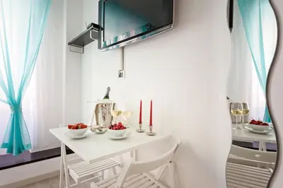 a white room with a desk and a tv on the wall at Relais 155 Guest House in Rome