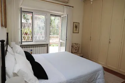 a bedroom with a white bed and a window at Luminoso e accogliente appartamento con giardino - Battistini in Rome