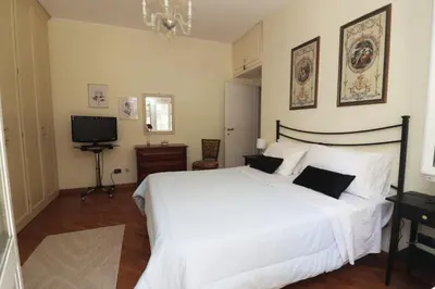 a bedroom with a large white bed and a television at Luminoso e accogliente appartamento con giardino - Battistini in Rome